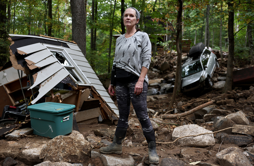 Liesl Steiner stands for a photo outside a destroyed garage of her flood damaged home in the aftermath of Hurricane Helene on Oct. 4, 2024, in Swannanoa, North Carolina. Steiner said a powerful mudslide carrying rocks and boulders tumbled down the mountainside and through part of her property. Many homes in the area were damaged by the mudslides. At least 227 people were killed in six states in the wake of the powerful hurricane which made landfall as a Category 4. It is now the deadliest U.S. mainland hurricane since Hurricane Katrina.