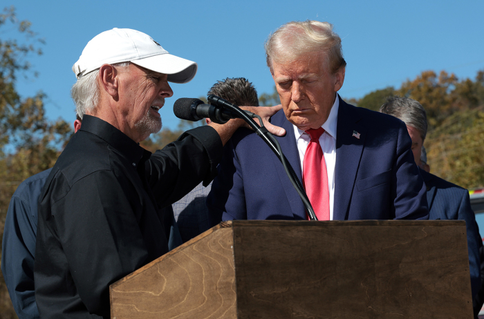 Mike Stewart, a local resident impacted by Hurricane Helene, prays with Republican presidential nominee, former U.S. President Donald Trump, as he tours a neighborhood affected by the hurricane on Oct. 21, 2024, in Swannanoa, North Carolina. 