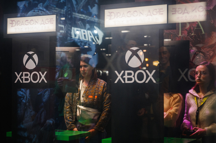 Visitors play the 'Dragon Age' video game by U.S. video game company Electronic Art on Xbox consoles during a press preview of the 'Paris Games Week' fair in Paris, France, on Oct. 22, 2024. 