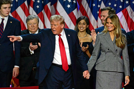 Former U.S. President and Republican presidential candidate Donald Trump gestures at supporters after speaking as he holds hands with former U.S. first lady Melania Trump during an election night event at the West Palm Beach Convention Center in West Palm Beach, Florida, early on Nov. 6, 2024. Republican former president Donald Trump closed in on a new term in the White House early Nov. 6, 2024, just needing a handful of electoral votes to defeat Democratic Vice President Kamala Harris.