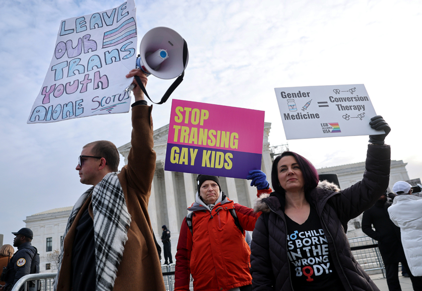 Trans activists, opponents and a supporter rally outside of the U.S. Supreme Court as the justices hear arguments in U.S. v. Skrmetti, a case about Tennessee's law banning puberty blockers, cross-sex hormones and body-mutilating surgeries for minors and whether it violates the Constitution’s equal protection guarantee on Dec. 04, 2024, in Washington, D.C. 