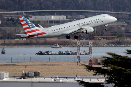 An American Eagle flight takes off from Reagan National Airport near where emergency crews work in the Potomac River on the crash site of an American Airlines plane on Jan. 30, 2025, in Washington, D.C. The American Airlines flight from Wichita, Kansas, collided in midair with a military helicopter while approaching the airport. According to reports, there were no survivors amongst the 67 people on board both aircraft.