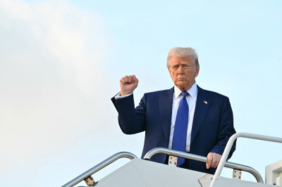 U.S. President Donald Trump pumps his fist as he steps off of Air Force One upon arrival at Palm Beach International Airport in West Palm Beach, Florida, on Feb. 14, 2025, en route to his Mar-a-Lago resort. 