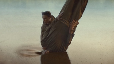 A character in KFC UKI's recent ad depicts a woman baptizing a man into a lake made of gravy before he emerges as a piece of fried chicken.