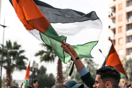 A man holds a Palestinian flag. 