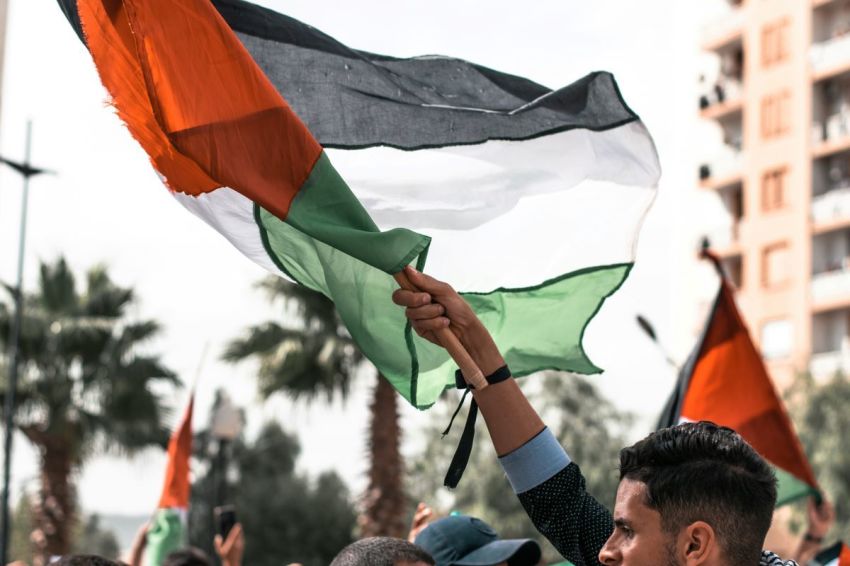 A man holds a Palestinian flag. 