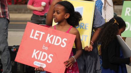 A little girl holding a "Let Kids be Kids" sign stands outside of the U.S. Supreme Court on April 22, 2025. The girl attended a rally in front of the court as it prepared to hear oral arguments for the case "Mahmoud v. Taylor."