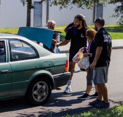 Volunteers with Celebration Church of Jacksonville, Florida, give away groceries to the less fortunate as part of their annual Serve Day event. 