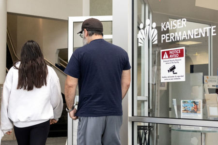 People walk past the entrance of Kaiser Permanente Medical Office in Manhattan Beach, California, on July 19, 2024. Kaiser Permanente activated their national command center as Airlines, banks, TV channels and other businesses were disrupted worldwide on July 19 following a major computer systems outage linked to an update on an antivirus program. 