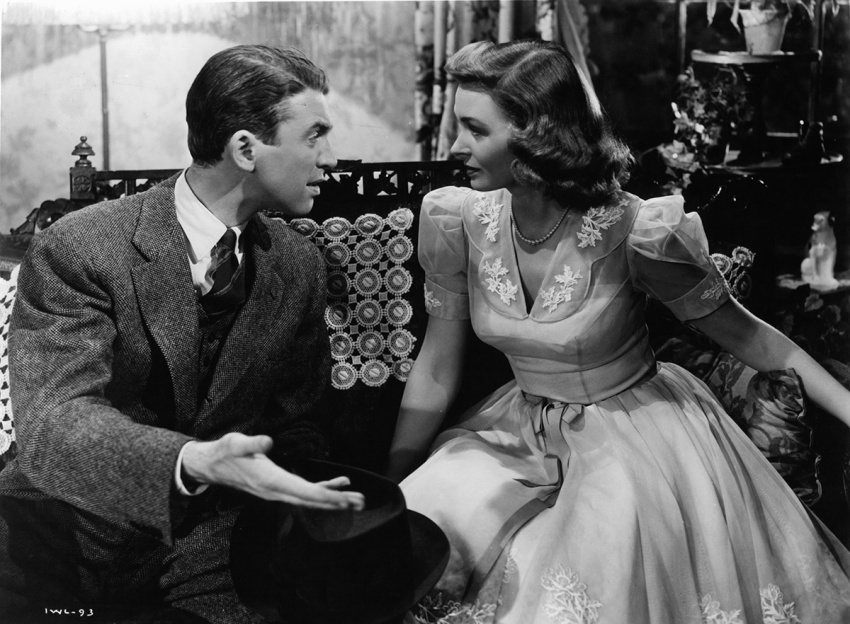 James Stewart sitting and talking with Donna Reed in a scene from the film 'It's A Wonderful Life,' 1946.