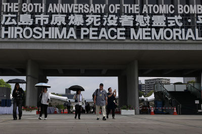  Visitors walk under a sign marking the 80th anniversary of the atomic bomb attack in World War II at the Hiroshima Peace Memorial on August 05, 2025 in Hiroshima, Japan. On August 6 and 9, 1945, the United States dropped atomic bombs on the Japanese cities of Hiroshima and Nagasaki, bringing unprecedented devastation and loss of life that led to the end of World War II.