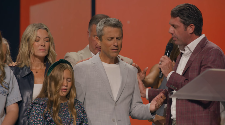 Non-staff Gateway Church Elder Tra Willbanks (R) prays over the church's new senior pastor, Daniel Floyd, and his family, during his official installation at the Southlake, Texas, church on Sunday August 17, 2025.