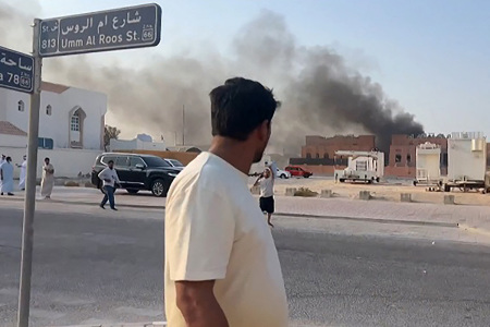 This frame grab taken from an AFPTV footage shows a man looking at smoke billowing after explosions in Doha's capital Qatar on Sept. 9, 2025. An Israeli military official told AFP that the military had carried out air strikes on Doha on Sept. 9 in an operation targeting senior leaders of the terrorist group Hamas.