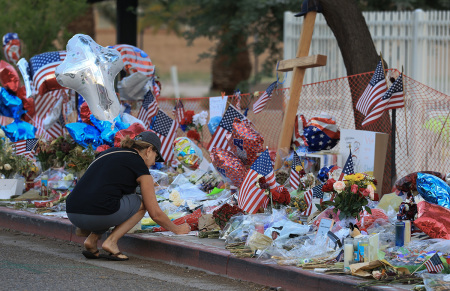 Cara Ediger visits the makeshift memorial for Charlie Kirk outside the headquarters of Turning Point USA on Sept. 19, 2025, in Phoenix, Arizona. Kirk, the CEO and co-founder of TPUSA, was shot and killed on Sept. 10 while speaking at an event for his "American Comeback Tour" at Utah Valley University. 
