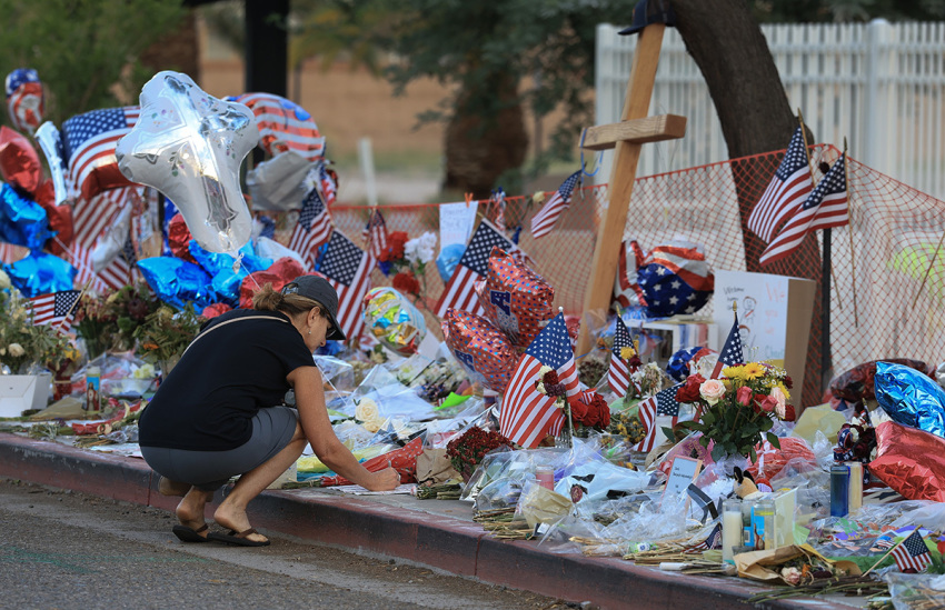 Cara Ediger visits the makeshift memorial for Charlie Kirk outside the headquarters of Turning Point USA on Sept. 19, 2025, in Phoenix, Arizona. Kirk, the CEO and co-founder of TPUSA, was shot and killed on Sept. 10 while speaking at an event for his "American Comeback Tour" at Utah Valley University.