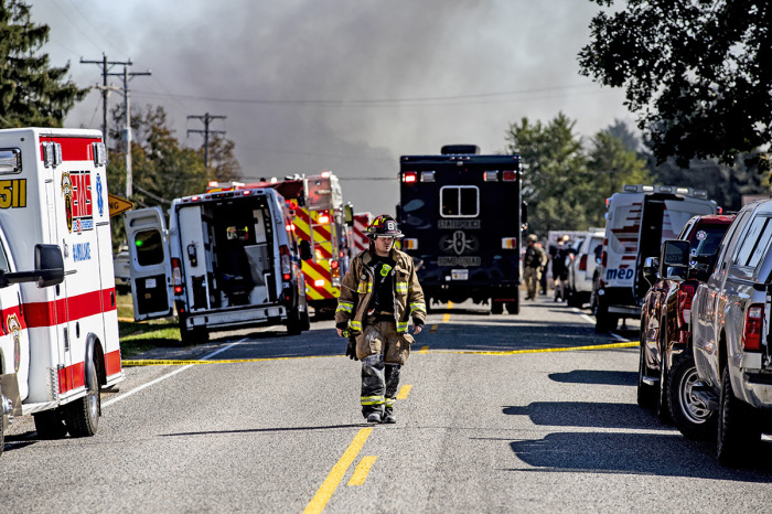 A firefighter walks down the street where emergency services are responding to a shooting and fire at the Church of Jesus Christ of Latter-day Saints on Sept. 28, 2025, in Grand Blanc, Michigan. According to police reports there are multiple victims and the shooter is down.