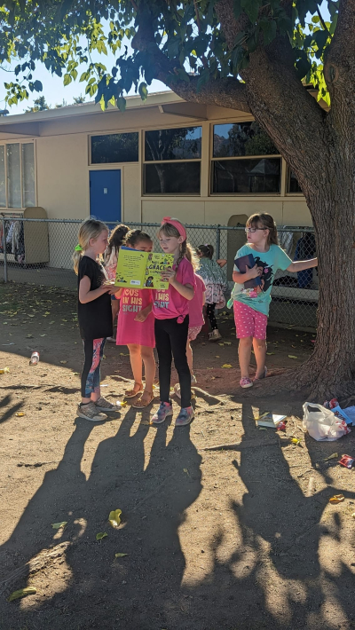 Lucie, a first-grader from California, reads the Bible to her classmates as they wait to be picked up from school.