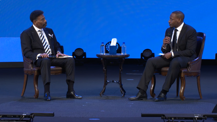 Tony Evans (L), founder of Oak Cliff Bible Fellowship Church in Dallas, Texas, talks with his son and the church's new lead pastor, Jonathan Evans (R), during his restoration ceremony on Oct. 5, 2025.