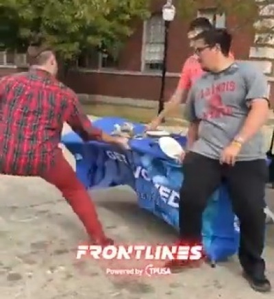 Graduate student Derek Lopez damages a Turning Point USA table presentation at Illinois State University on Oct. 17, 2025.
