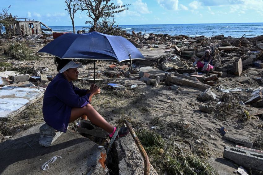Residents rest amid debris of a damaged house after the passage of Hurricane Melissa in Boca de Dos Rios village, Santiago de Cuba province, Cuba, on Oct. 30, 2025.