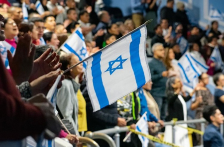 Hundreds of attendees raise Israeli flags in the auditorium of Breath of Life Church in Queens, New York, during the "New York Blesses Israel" event on Nov. 5, 2025. The congregation, which gathered more than 1,000 people, stood up to show their support and solidarity with the Jewish people in a moment described by pastors as "emotional."
