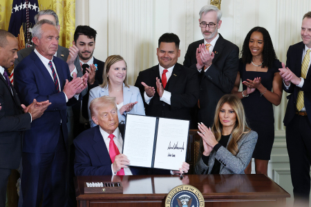 U.S. President Donald Trump, joined by first lady Melania Trump, members of his administration and foster care advocates, signs the "Fostering the Future" executive order in the East Room of the White House on Nov. 13, 2025, in Washington, D.C. The executive order, championed by the first lady, works to expand opportunities for education, career development, housing and other resources for youth transitioning from foster care to adulthood.