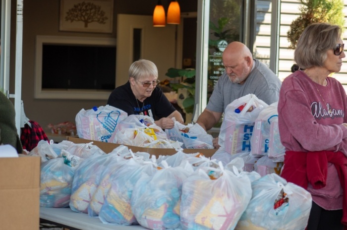 Volunteers with Solid Rock Church of Midland, Georgia, help distribute groceries during a giveaway event on Nov. 15, 2025.