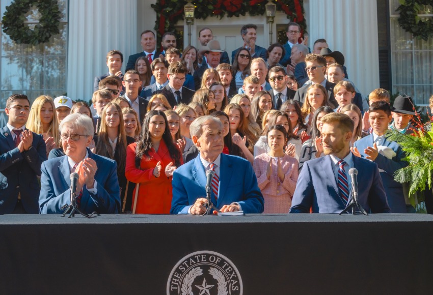Texas Gov. Greg Abbott (center) is joined by Lt. Gov. Dan Patrick and Texas Education Agency (TEA) Commissioner Mike Morath along with TPUSA supporters at the Governor's Mansion in Austin, Texas on Dec. 8, 2025.