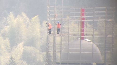 Workers stand on a scaffolding surrounding the cross atop Yayang Christian Church in Wenzhou, China, on Jan. 6, 2025.