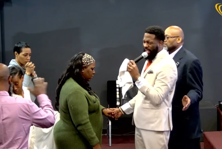 Ricky Lee Taylor, senior pastor of Arena of Praise in Chattanooga, Tenn. prays for one of his parishioners.