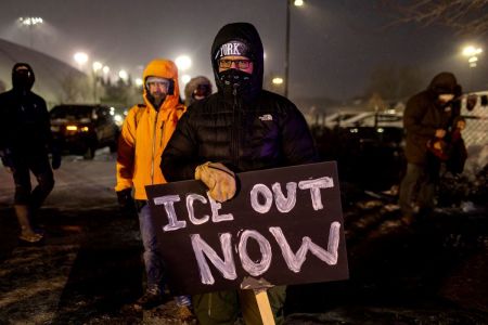 A protester with an anti-ICE sign stands outside of the Henry Bishop Whipple Federal building on January 18, 2026, in Minneapolis, Minnesota. 