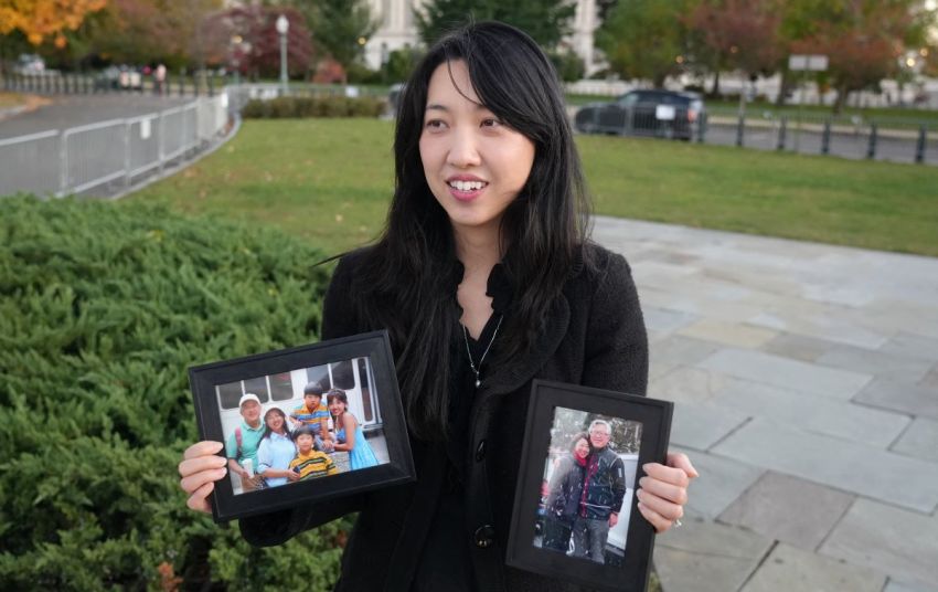Grace Jin Drexel, daughter of Jin Mingri, who is also known as Ezra, a pastor of an "underground" church who was detained in the Beihai City of Guangxi region in China this month, holds up two framed photos, one of her father, mother and brothers, and another of her parents, during an interview in Washington, DC on October 30, 2025.