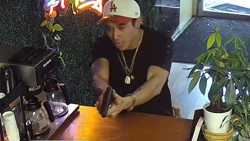 The unidentified man who was recorded robbing the owner of Arepa Express in Melrose Park, Illinois, on May 12, 2026.