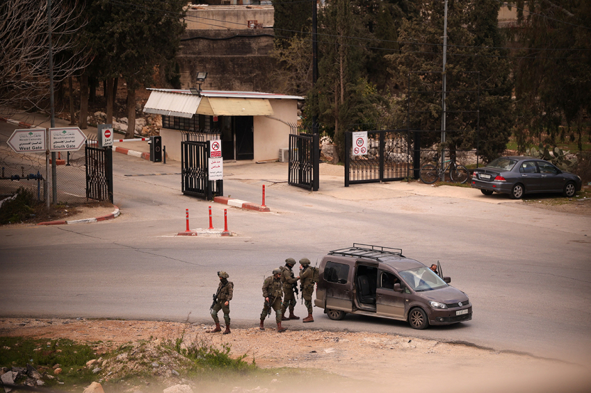 Israeli soldiers stop and inspect a Palestinian vehicle at a temporary checkpoint near the entrance to Birzeit University, north of Ramallah, in the occupied West Bank, on Feb. 23, 2026. 