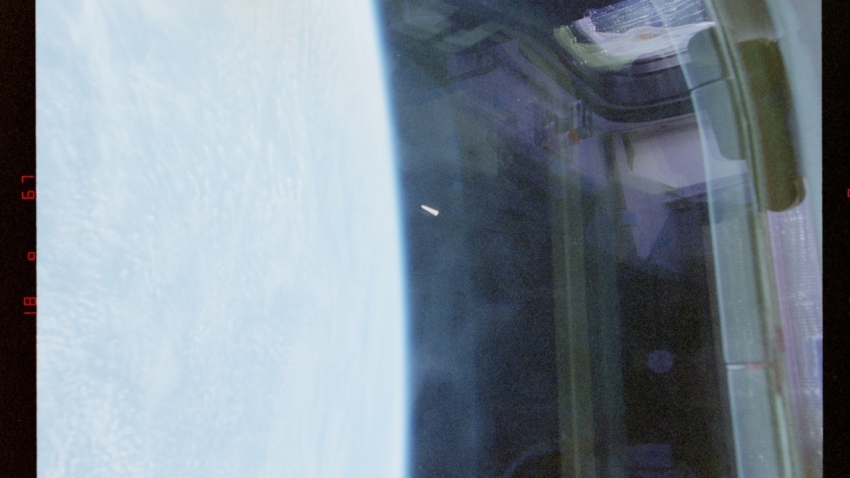 An object in low-Earth orbit photographed by NASA astronauts in 1996 aboard Space Shuttle Columbia. The object is visible near the center of the frame, to the right of the limb of Earth.