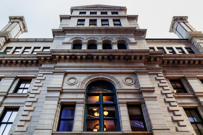 Close-up detail view of the John Adams Courthouse building in Boston, Massachusetts, on June 12, 2026. The John Adams Courthouse (aka The Suffolk County Courthouse) houses the Massachusetts Supreme Judicial Court, the Massachusetts Appeals Court, and the Social Law Library, which is the nation's oldest law library. It is a historic courthouse building in Pemberton Square. Built in 1893, it was the major work of Boston's first city architect, George Clough, and is one of the city's few surviving late 19th-century monumental civic buildings. It was added to the National Register of Historic Places in 1974. 