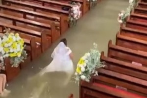 Couple marries in flooded church after monsoon in Philippines; bride walks the aisle in waist-deep water
