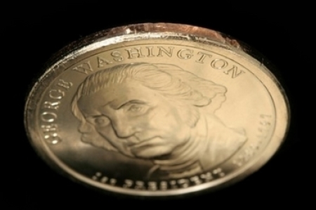 In this undated photo released by Professional Coin Grading Service, a George Washington dollar coin missing the edge inscription is shown. An unknown number of new George Washington dollar coins were struck without their edge inscriptions, including 'In God We Trust,' and made it past inspectors and into circulation, the U.S. Mint said Wednesday, March 7, 2007.