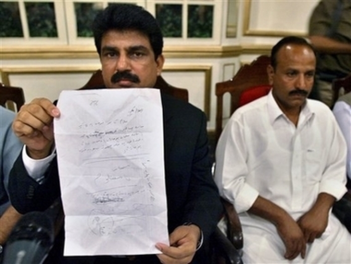 Head of All Pakistan Minorities Alliance Shahbaz Bhatti, left, shows a threatening letter which Michael Javed, right, a Christian resident of Charsadda town, received during a press conference in Islamabad, Pakistan, Wednesday, May 16, 2007. Pakistani Christians living in a town beset by pro-Taliban militants sought government protection, a day before the expiry of an ultimatum warning them to convert.