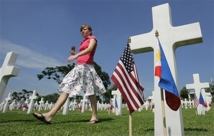 An American girl passes by tombstones during the commemoration of U.S. Memorial Day at the Manila American Cemetery in suburban Manila on Sunday May 27, 2007. More than 17,000 American military dead have been laid to rest at the Manila American Cemetery and Memorial, which contains the largest number of graves of US military dead from World War II, most of whom lost their lives in operations in New Guinea and the Philippines.