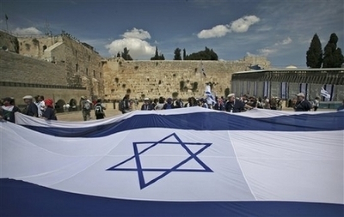 Credit : Jewish people display a Israeli flag, during celebrations for Israel's 60th anniversary next to the Western Wall, Judaism's holiest site in Jerusalem's Old City, Thursday, May 8, 2008. Israel is marking its 60th Independence Day, which began at sundown We