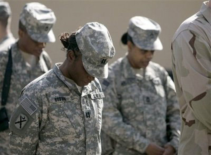 U.S soldiers of Combined Security Transition Command stand silent and bow their heads during a ceremony marking Veterans Day at the Camp Eggers in Kabul, Afghanistan, Tuesday, Nov. 11, 2008.