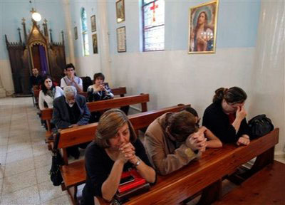 Credit : Palestinian Christians attend a Sunday mass at the Latin church in Gaza City, Sunday, May 10, 2009. Pope Benedict XVI on Sunday urged Middle East Christians to persevere in their faith despite hardships threatening the existence of their ancient communiti