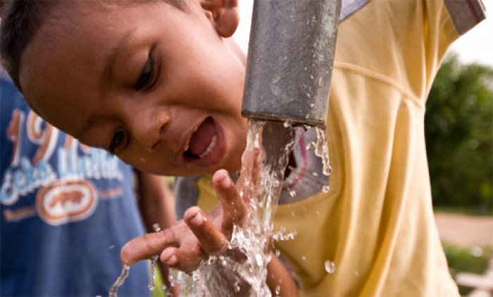 A small boy drinks from a Saks Fifth Avenue-funded water well in Brus Laguna in Honduras.