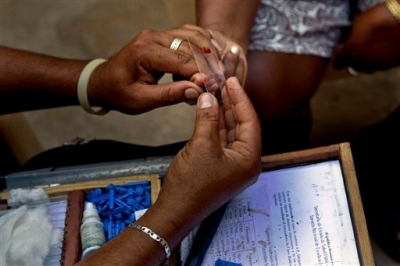 A health service worker takes a blood sample for a malaria test.