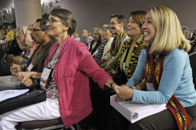 Observers Tricia Dykers Koenig, left, and Michelle Ready, right, smile as the General Assembly of the Presbyterian Church meeting Thursday, July 8, 2010 in Minneapolis votes to approve lifting the churches ban on ordaining non-celebrate gays and lesbians as clergy.