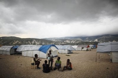 In this photo taken May 31, 2010, people sit in the Corail-Cesselesse camp for earthquake displaced people on the outskirts of Port-au-Prince, Haiti.