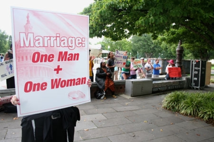 In this file photo, a traditional marriage supporter holds up a sign defending marriage as a union between a man and a woman during a rally in Washington, D.C., Aug. 15, 2010.