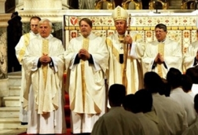 Three former Anglican bishops, John Broadhurst, left, Andrew Burnham, second left, and Keith Newton, right, stand with Archbishop Vincent Nichols, the leader of Catholics in England and Wales, after they were ordained as Catholic priests in Westminster Cathedral, London, Saturday Jan. 15, 2011.