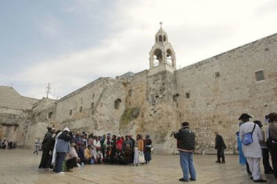Tourists take photographs outside the Church of Nativity, traditionally believed by many Christians to be the birthplace of Jesus Christ, in the West Bank town of Bethlehem, Monday, Feb. 7, 2011. The Palestinian Authority said Monday it has asked the U.N.'s cultural agency in January to designate the church built at the traditional birth site of Jesus as the first world heritage site in the Palestinian territories.